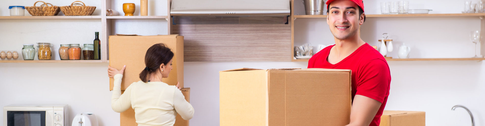 a man looking at the camera smiling while holding a box