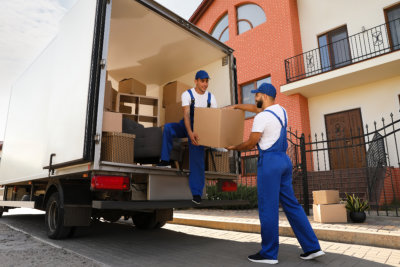 Workers unloading boxes from van outdoors