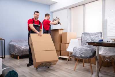 Male Mover Packing The Products In The Cardboard Boxes