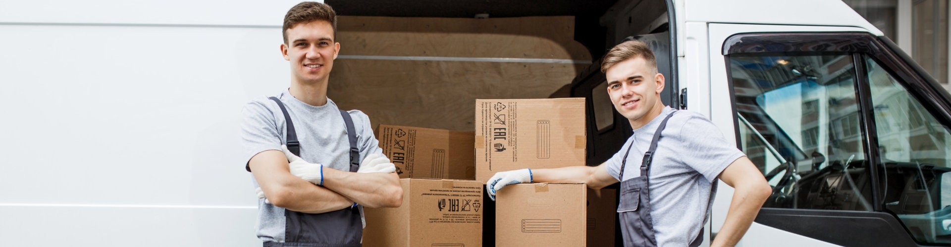 workers wearing uniforms are standing next to the van full of boxes