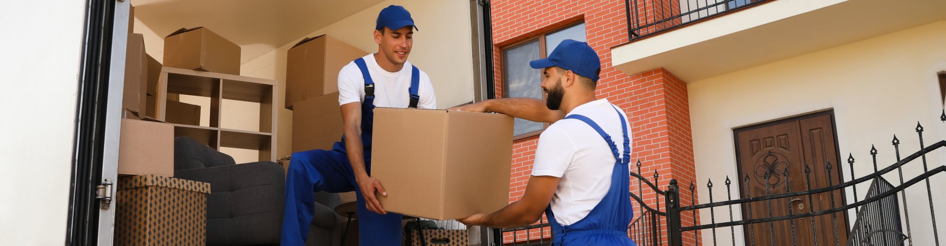 Workers unloading boxes from van outdoors