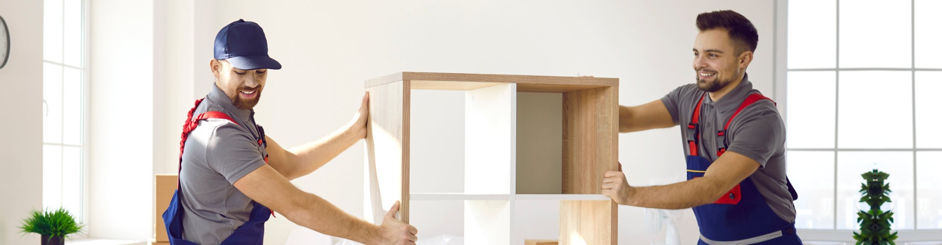 movers in uniform carry shelves